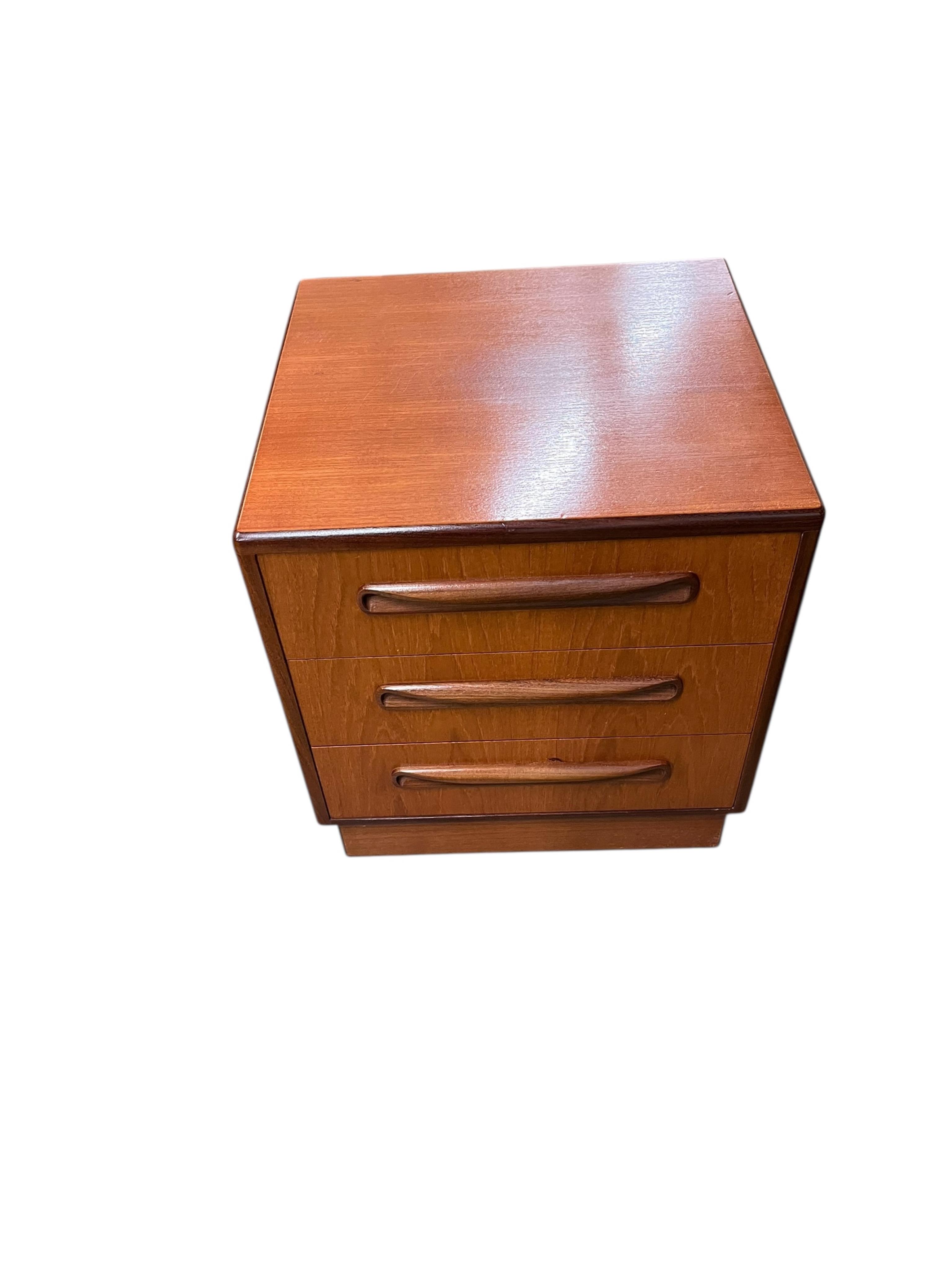 A mid century G Plan Fresco teak bedroom suite comprising a three door wardrobe, a two door wardrobe, two six drawer chests, dressing table, headboard and a pair of bedside chests